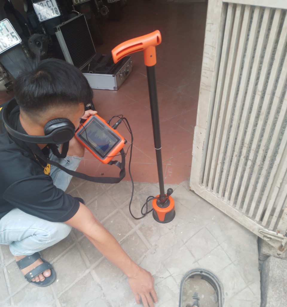 Kỹ thuật viên sử dụng máy siêu âm để dò tìm rò rỉ nước trong nhà dân tại Quảng Ninh